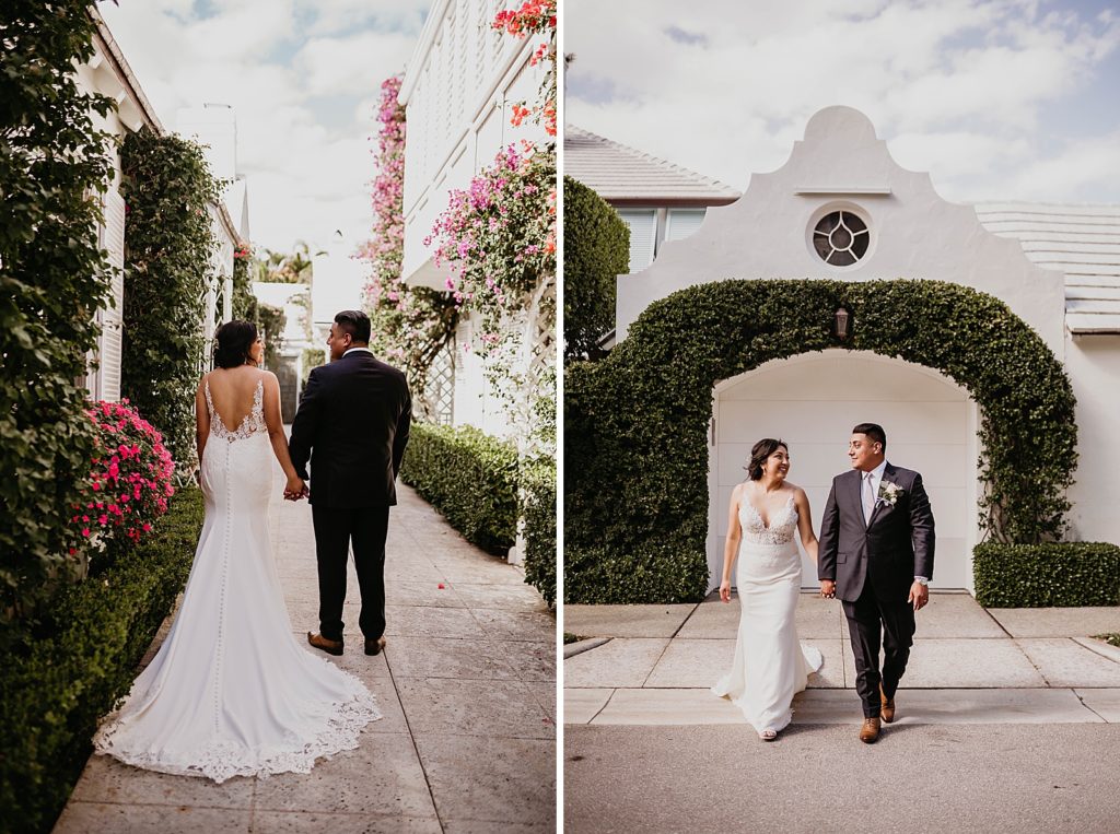 Bride and Groom holding hands by green hedge