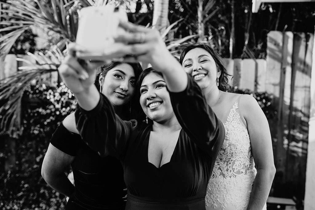 B&W Bride taking a selfie with guests
