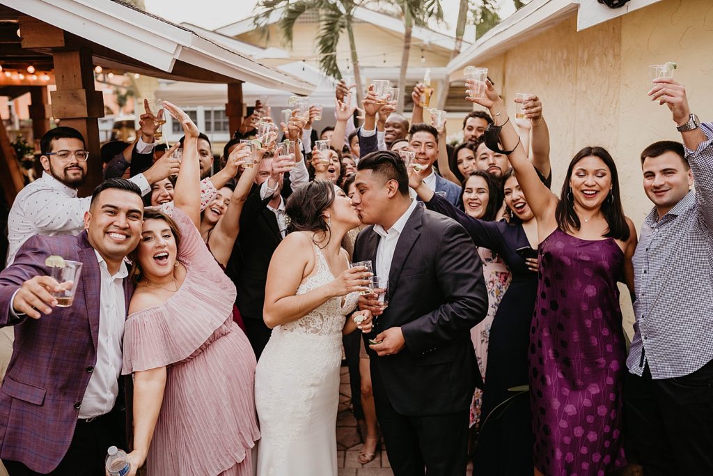 Bride and Groom kissing with guests all around them