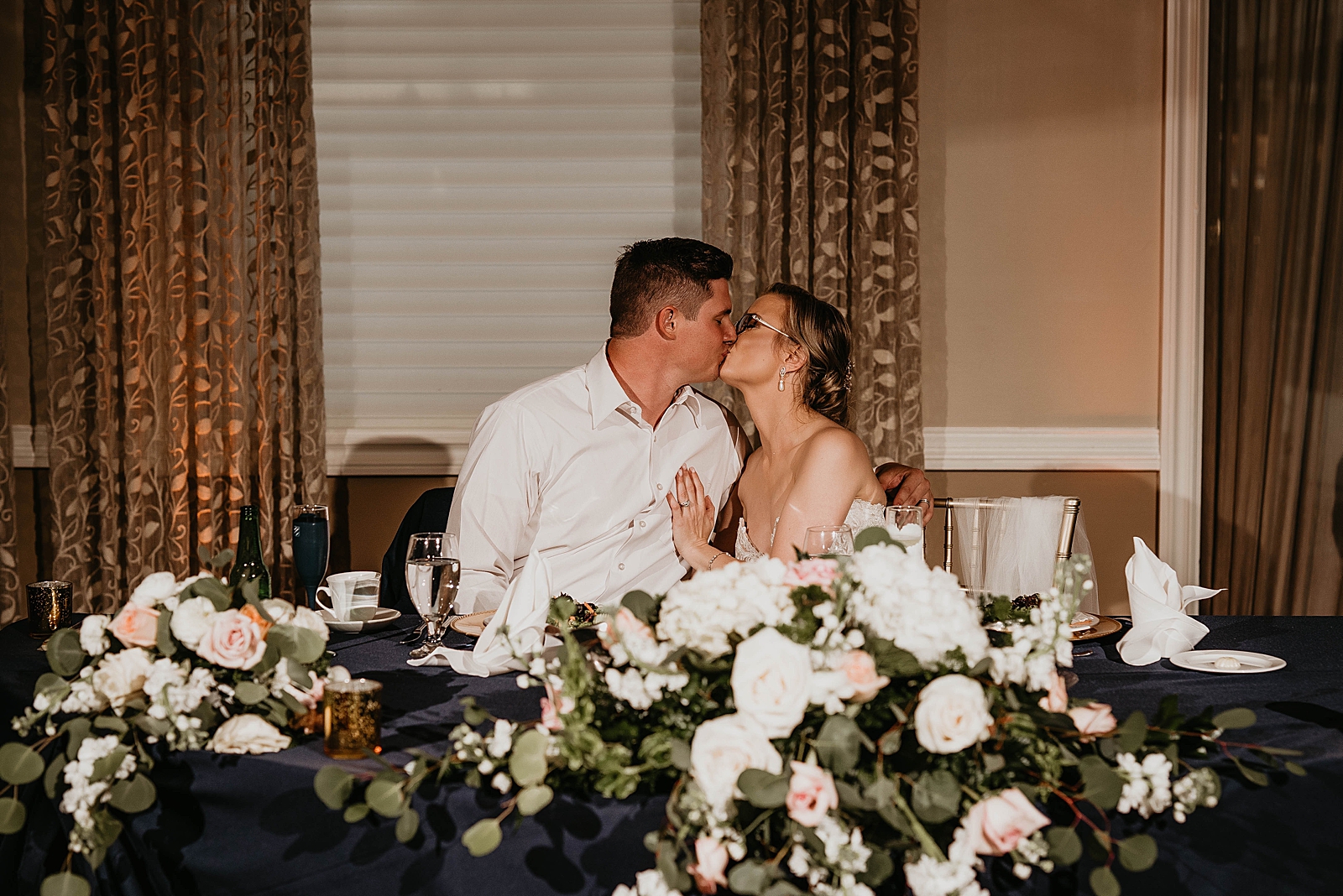Bride and Groom kissing at sweetheart table