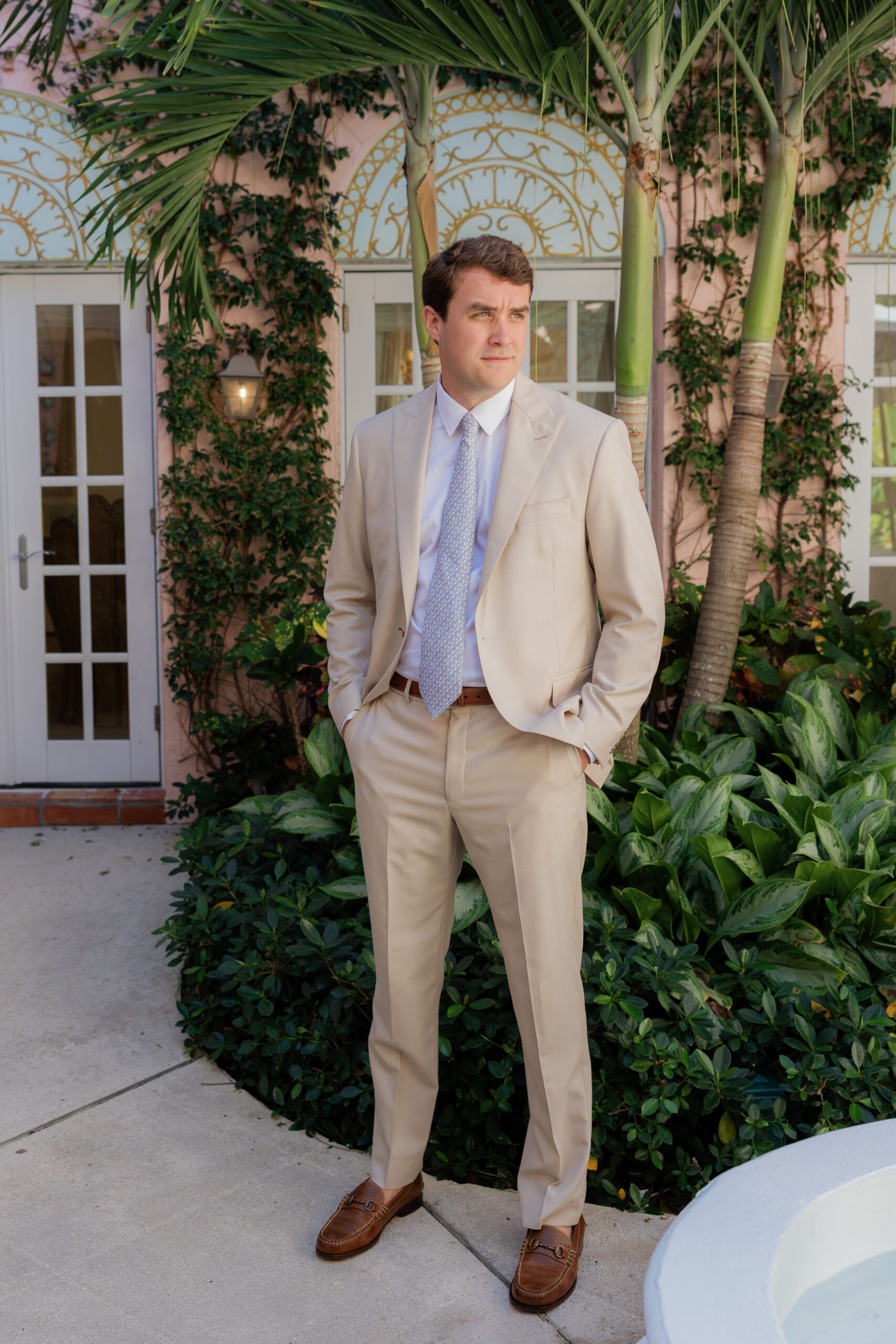 Harper and Luke wedding at The Colony Palm Beach - getting ready - A man in a light suit poses for a portrait outdoors, likely before the wedding c