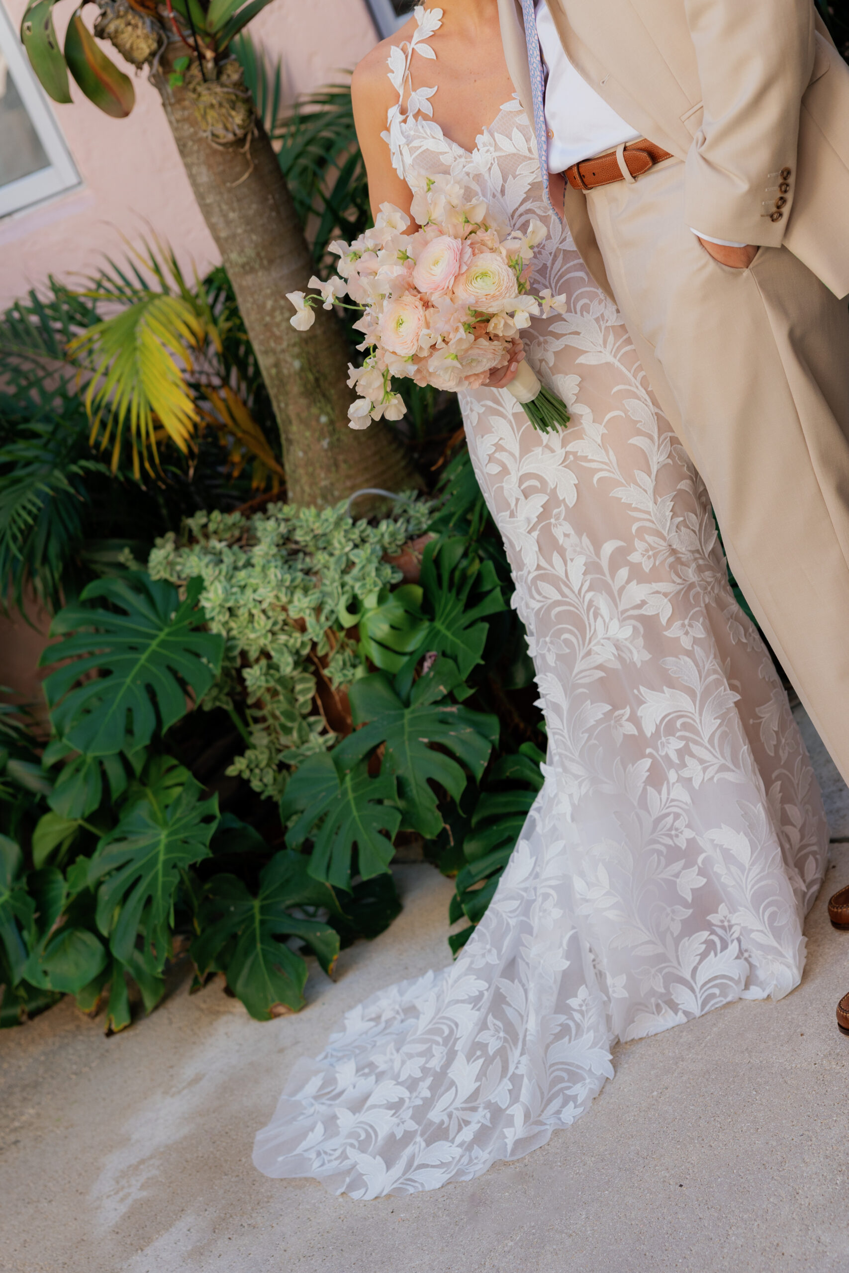 Harper and Luke wedding at The Colony Palm Beach - getting ready - A bride in a white lace wedding dress holding a bouquet stands next to the groom