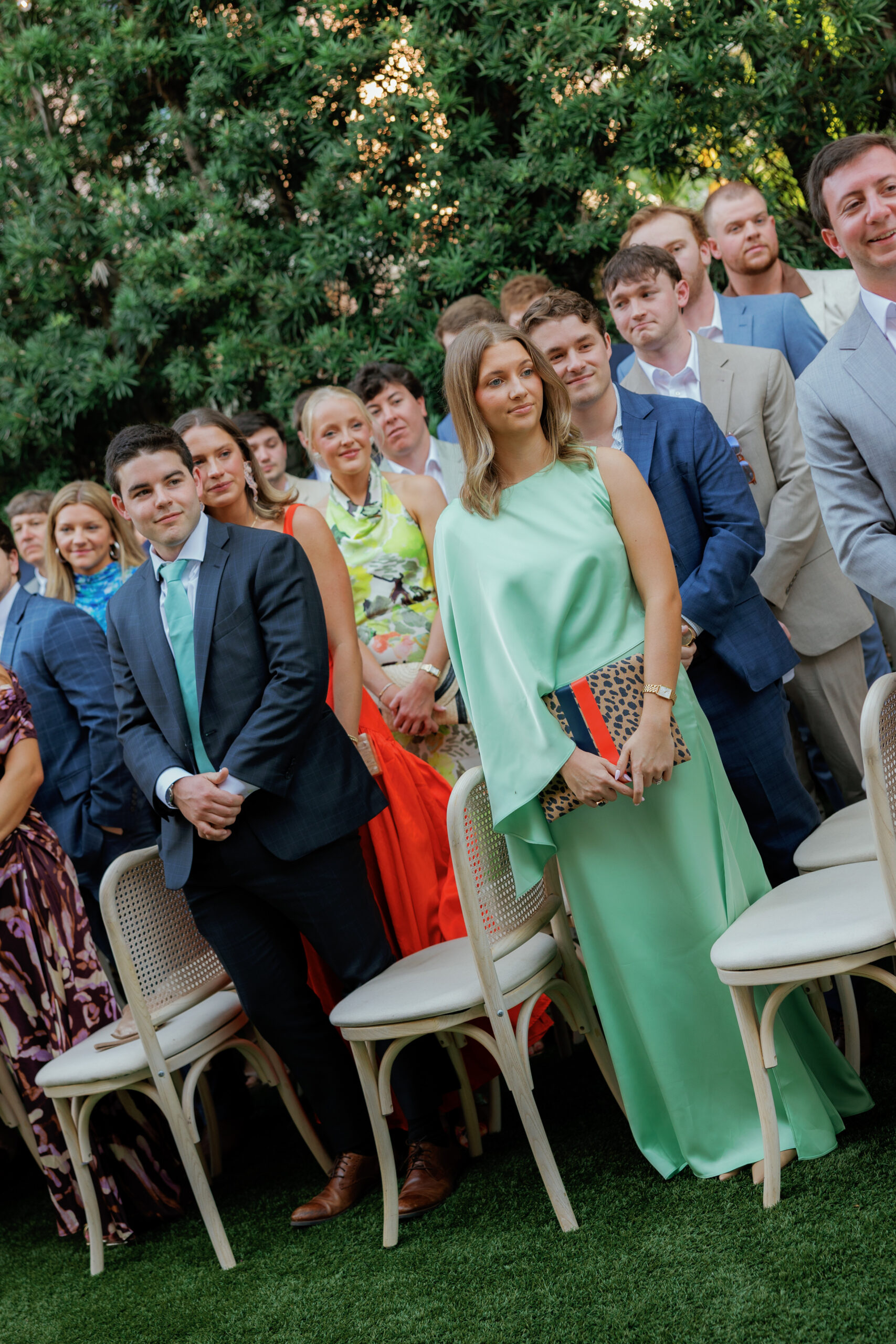 Harper and Luke wedding at The Colony Palm Beach - ceremony - Guests are seated outdoors, attentively watching an event, likely a wedding cere