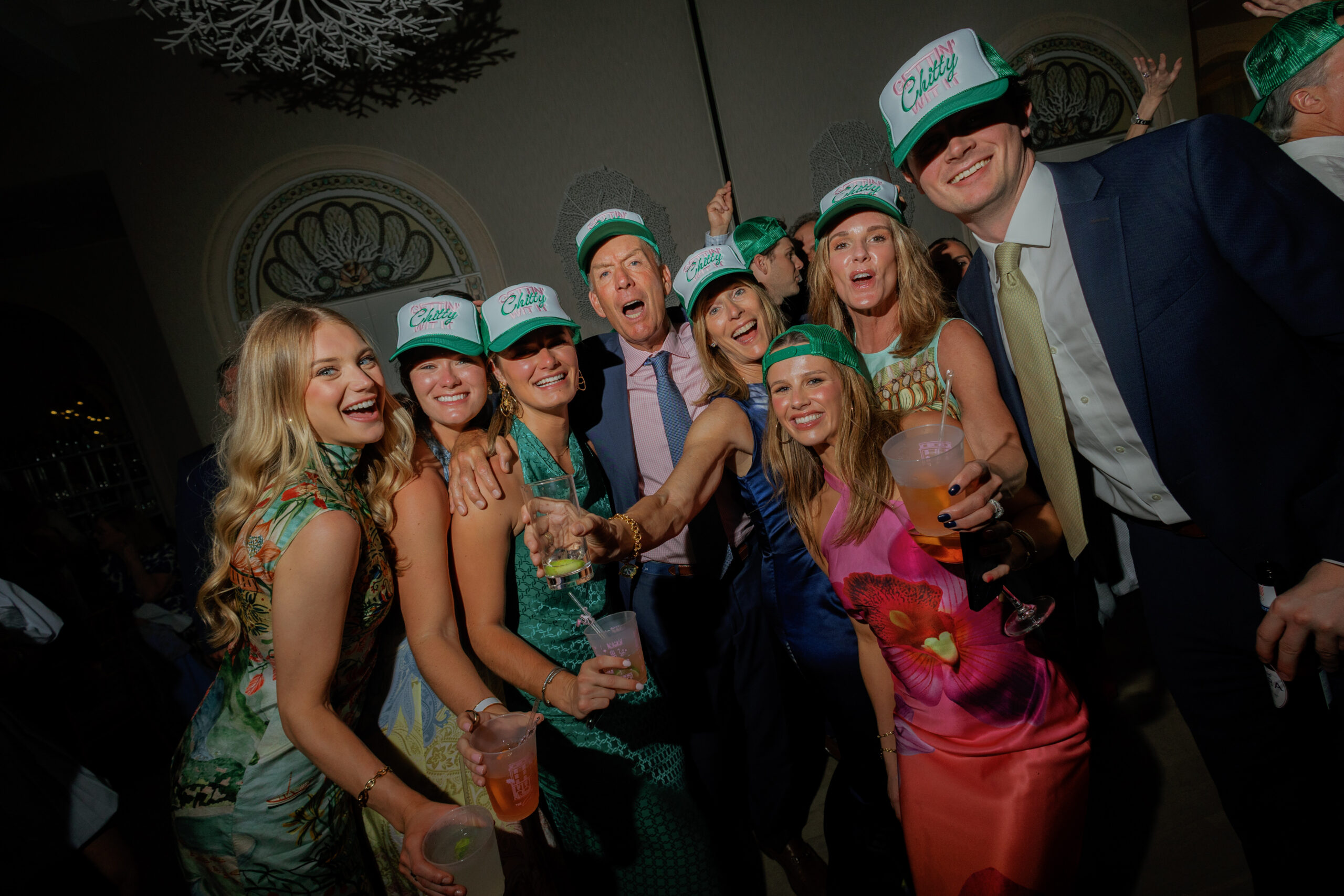 Harper and Luke wedding at The Colony Palm Beach - reception - A group of guests wearing hats and holding drinks, smiling and celebrating at th
