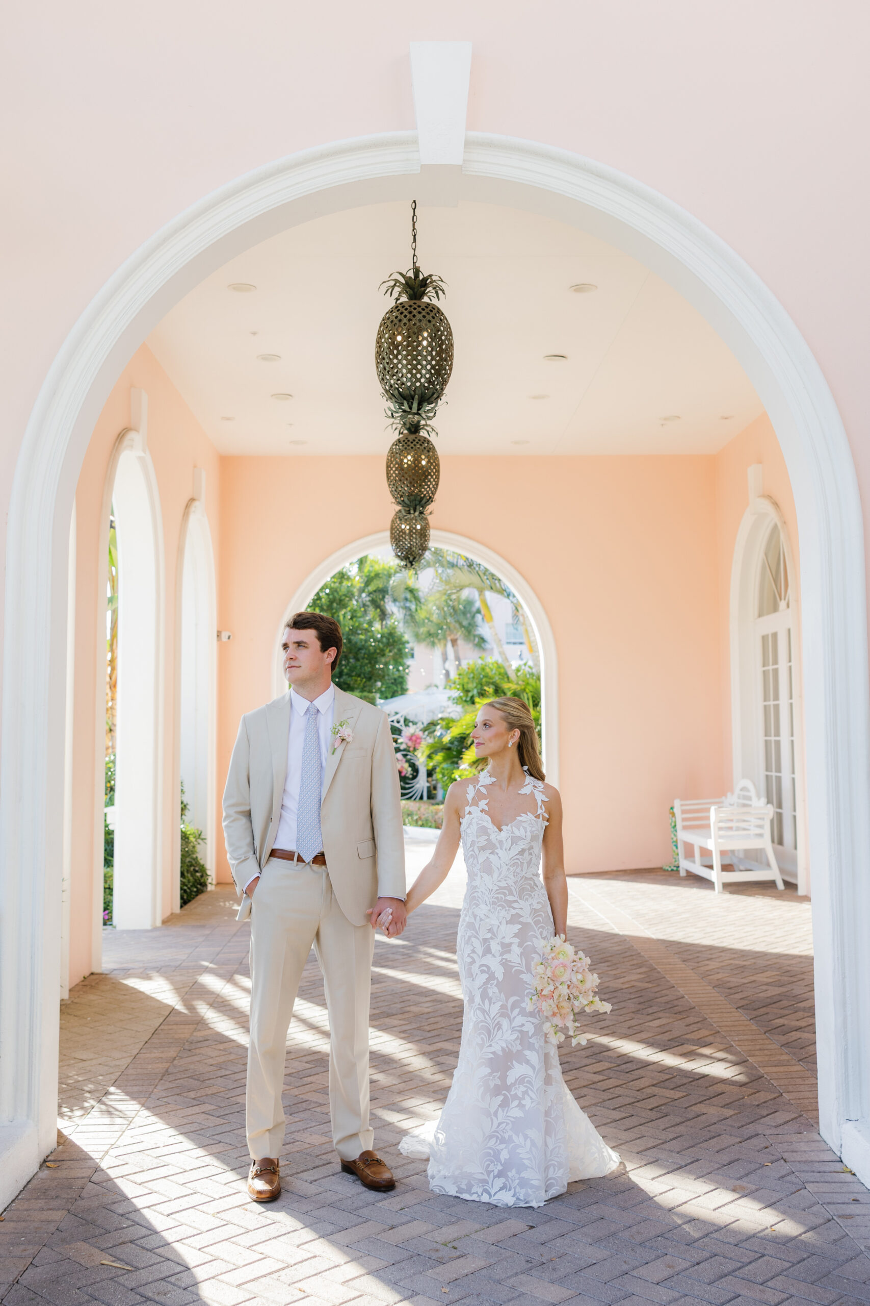 Harper and Luke wedding at The Colony Palm Beach - getting ready - A newlywed couple poses for a portrait in a beautiful arched walkway with tropic
