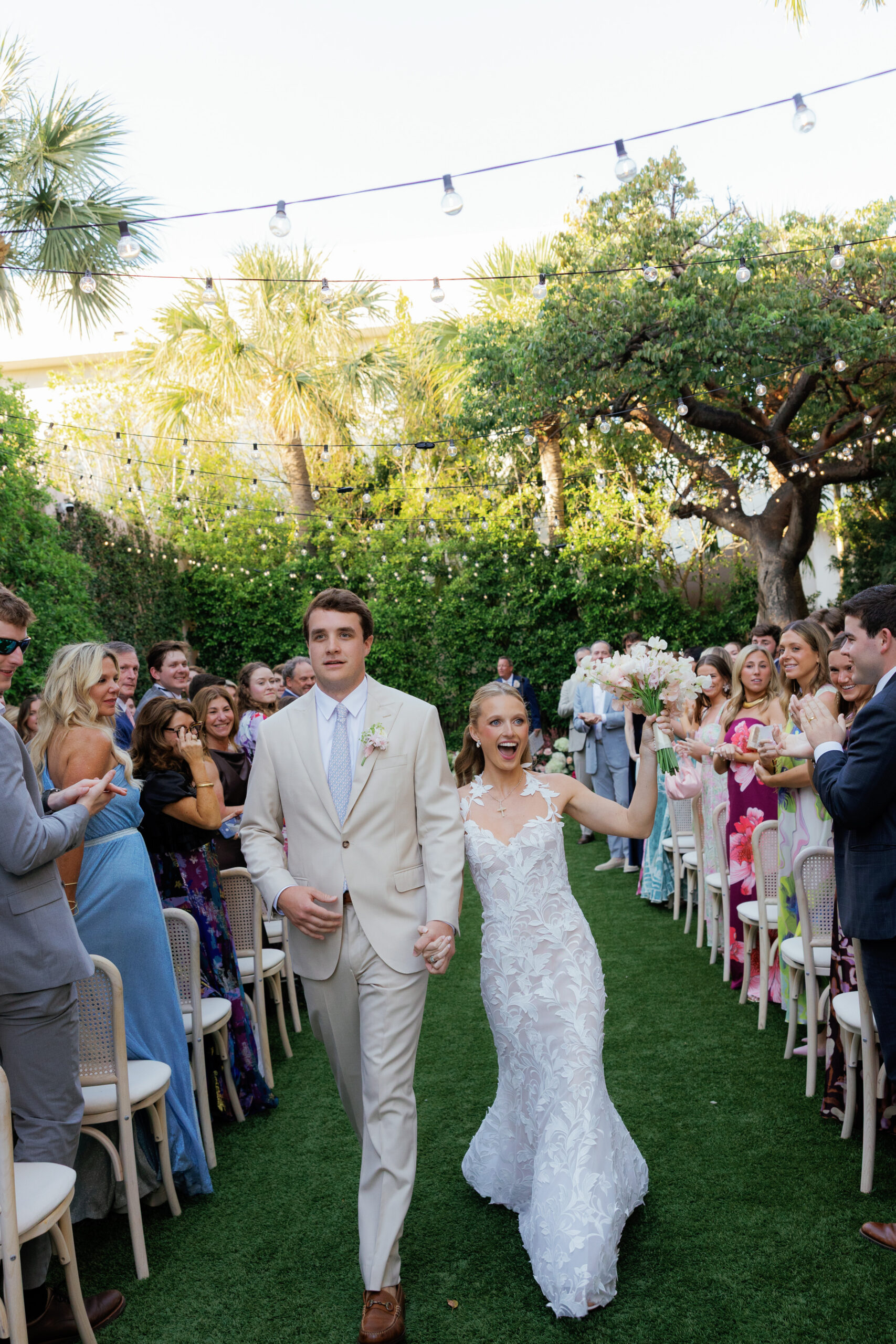 Harper and Luke wedding at The Colony Palm Beach - ceremony - The bride and groom walk down the aisle, celebrating with guests after their wed
