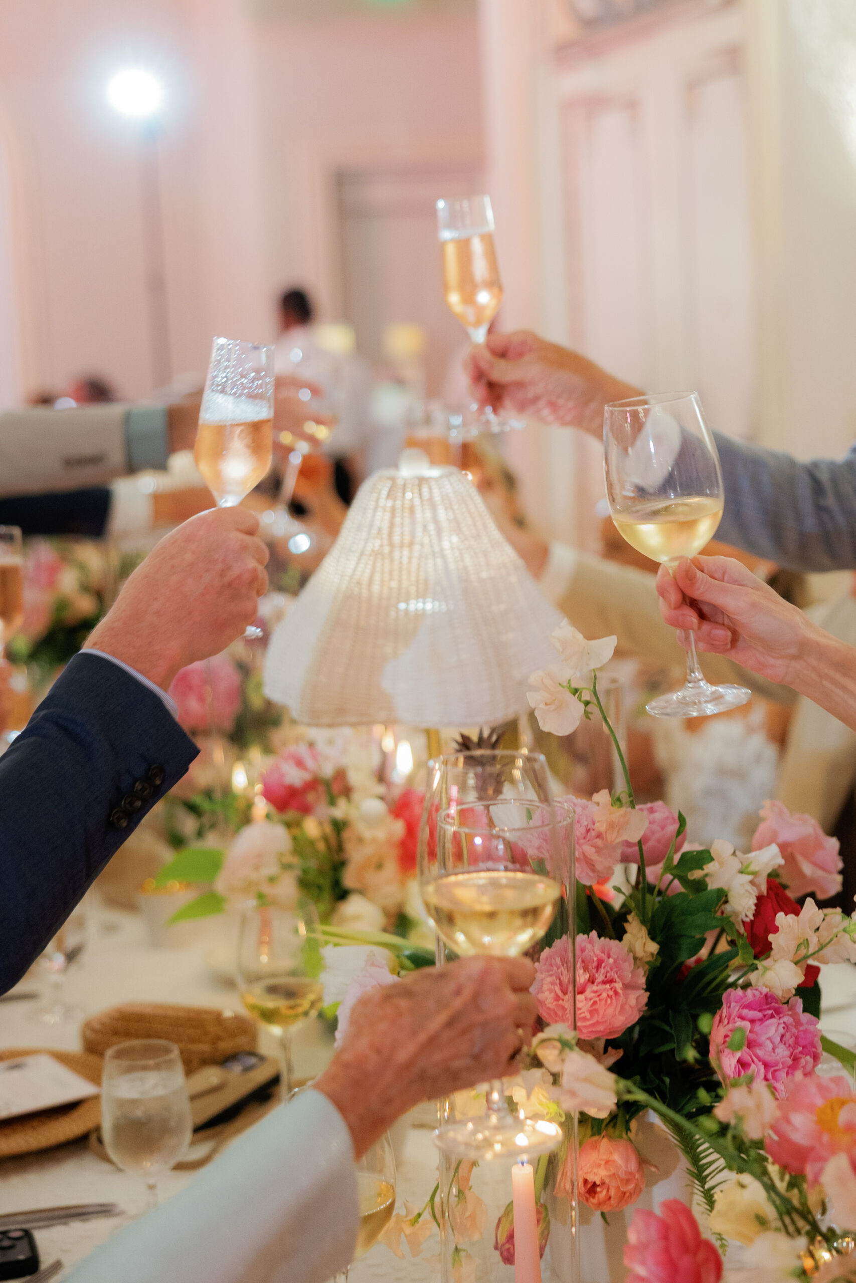 Harper and Luke wedding at The Colony Palm Beach - reception - Guests raise glasses for a toast at a beautifully decorated reception table with