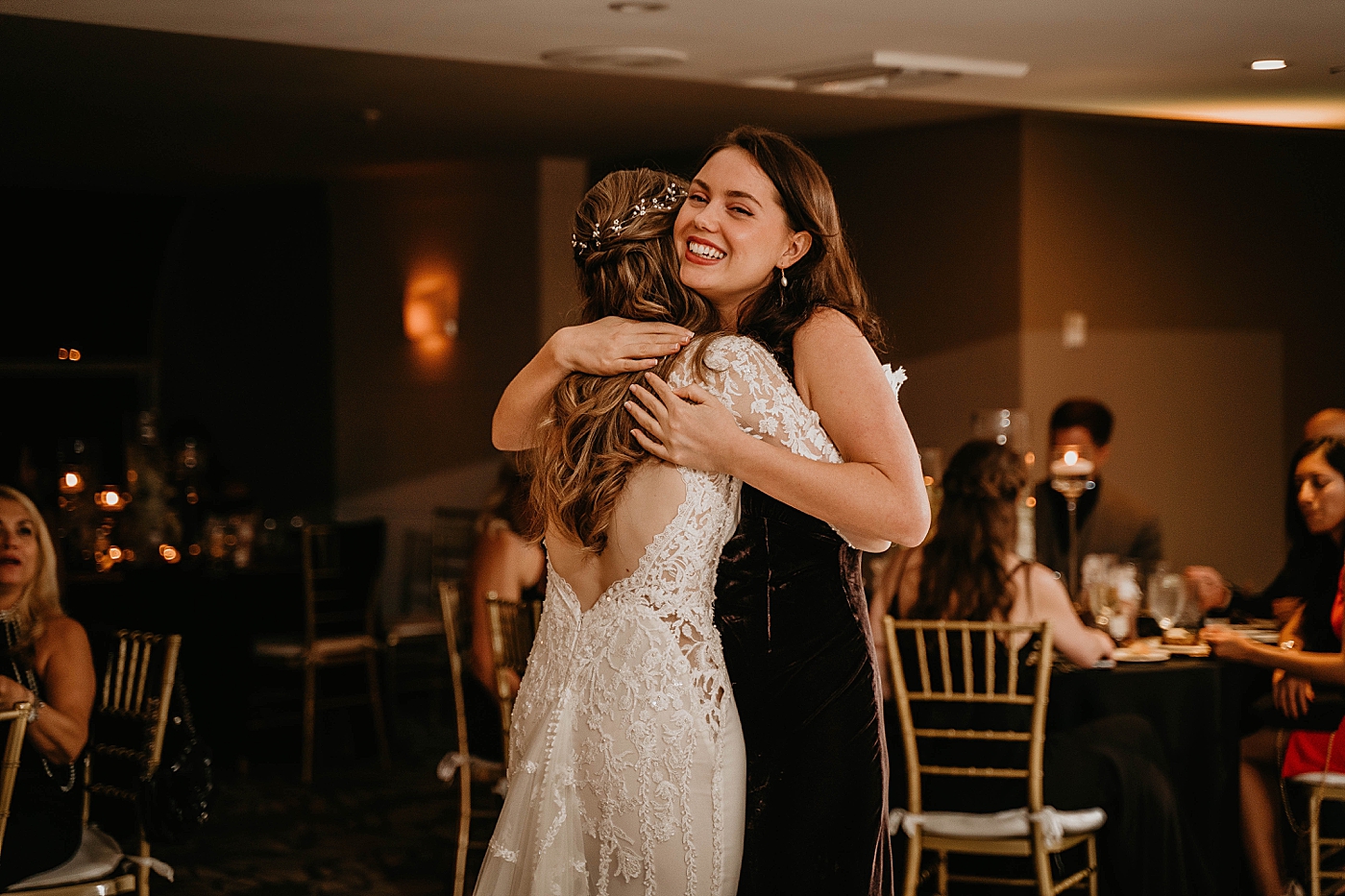 Bride and Maid of Honor hugging at Reception Waterstone Resort and Marina Wedding captured by South Florida Wedding Photographer Krystal Capone Photography