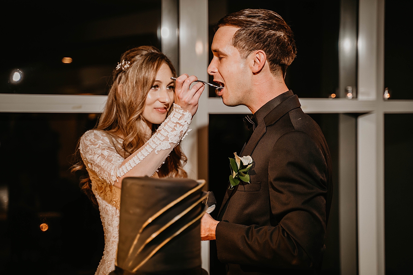 Bride feeding Groom a bite of cake Waterstone Resort and Marina Wedding captured by South Florida Wedding Photographer Krystal Capone Photography