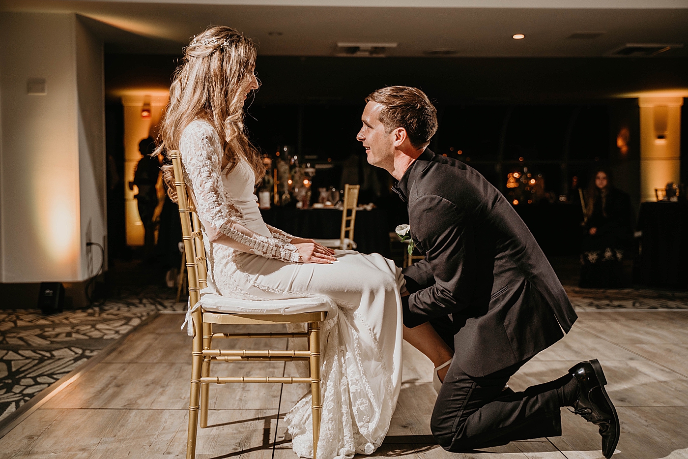 Groom getting the garter Reception Waterstone Resort and Marina Wedding captured by South Florida Wedding Photographer Krystal Capone Photography