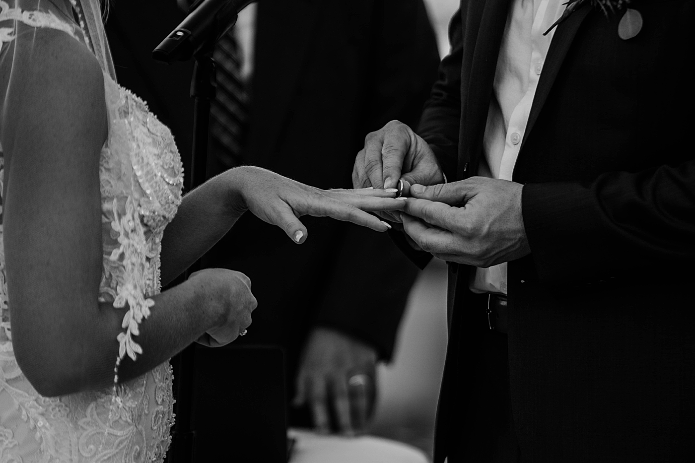 Groom putting wedding band on Bride B&W Out of the Blue Celebrations Wedding Photography captured by South Florida Wedding Photographer Krystal Capone Photography 