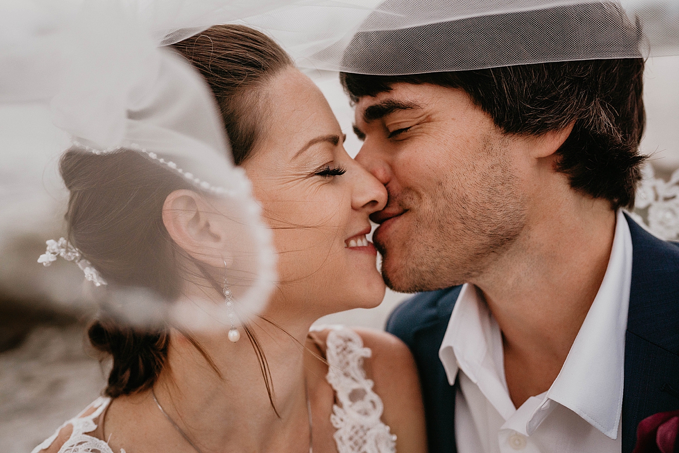 Bride and Groom under the veil about to kiss Out of the Blue Celebrations Wedding Photography captured by South Florida Wedding Photographer Krystal Capone Photography 