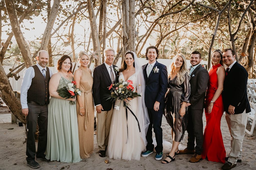 Bride and Groom standing together with family and friends Jupiter Beach Resort Wedding Photography captured by South Florida Wedding Photographer Krystal Capone Photography 