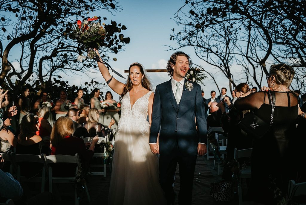 Bride and Groom exiting Ceremony hand in hand Jupiter Beach Resort Wedding Photography captured by South Florida Wedding Photographer Krystal Capone Photography 
