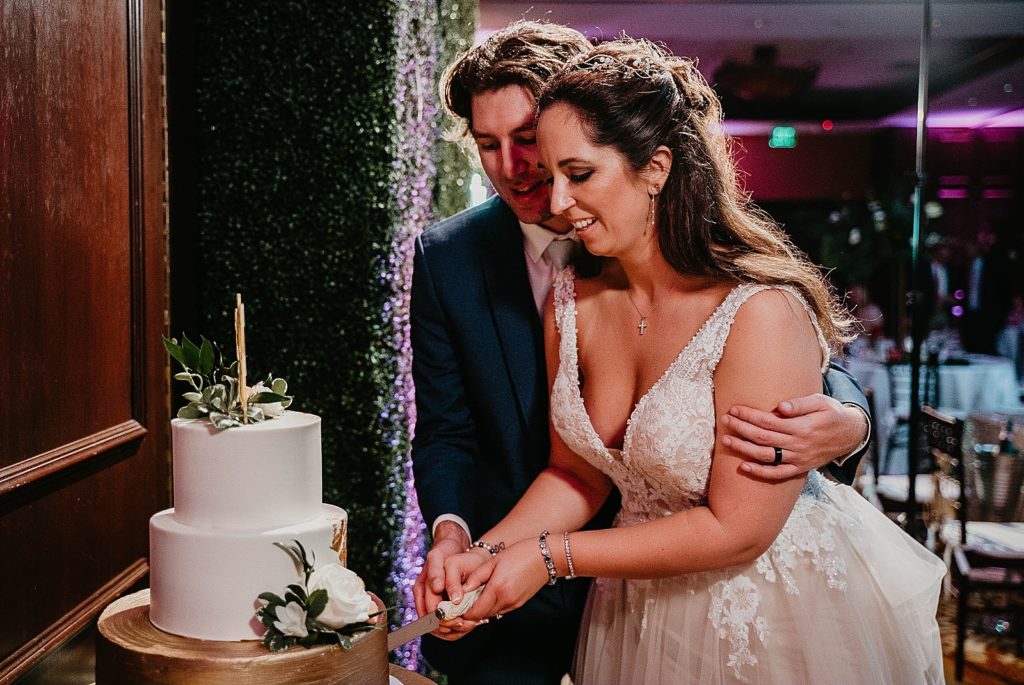 Bride and Groom cutting wedding cake Jupiter Beach Resort Wedding Photography captured by South Florida Wedding Photographer Krystal Capone Photography 
