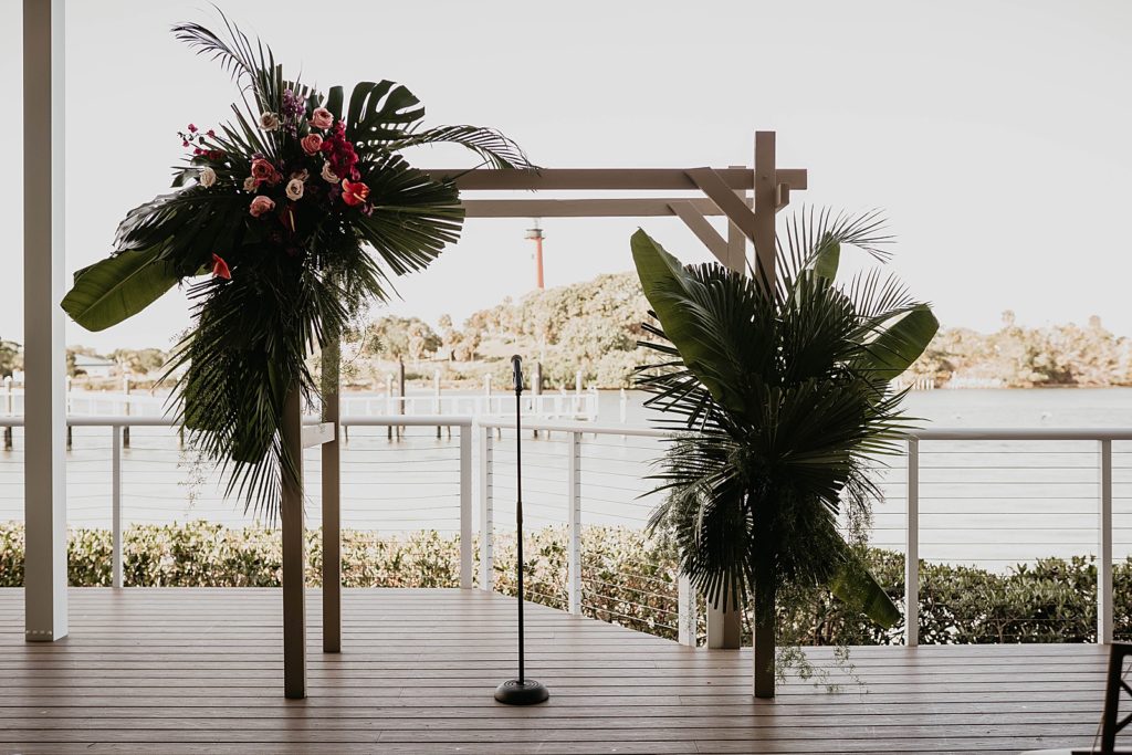 Ceremony detail shot of arch with tropical greenery Pelican Club Wedding Photography captured by South Florida Wedding Photographer Krystal Capone Photography 