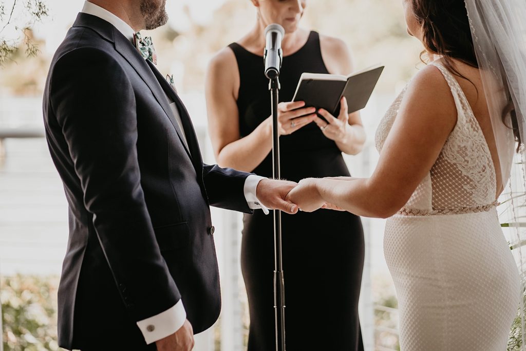 Bride putting wedding band on Groom's finger during ceremony Pelican Club Wedding Photography captured by South Florida Wedding Photographer Krystal Capone Photography 