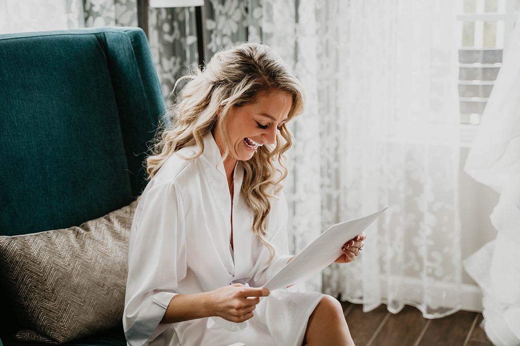 Bride reading letter and laughing before Getting Ready Pelican Club Wedding Photography captured by South Florida Wedding Photographer Krystal Capone Photography