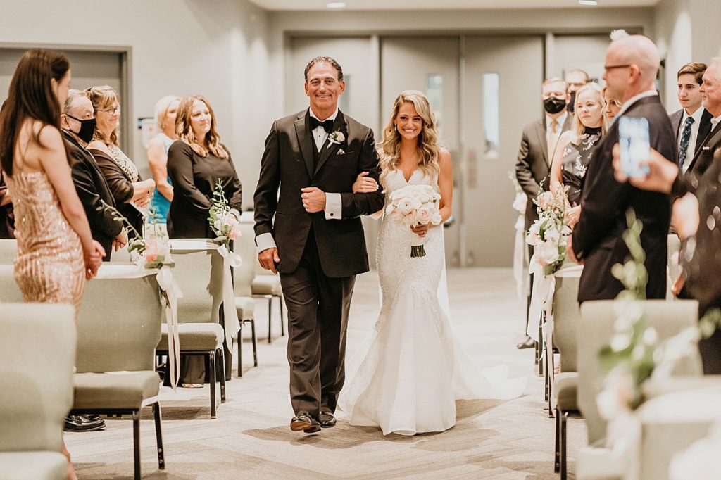 Wedding attendees standing s Father and Bride enter the ceremony Pelican Club Wedding Photography captured by South Florida Wedding Photographer Krystal Capone Photography