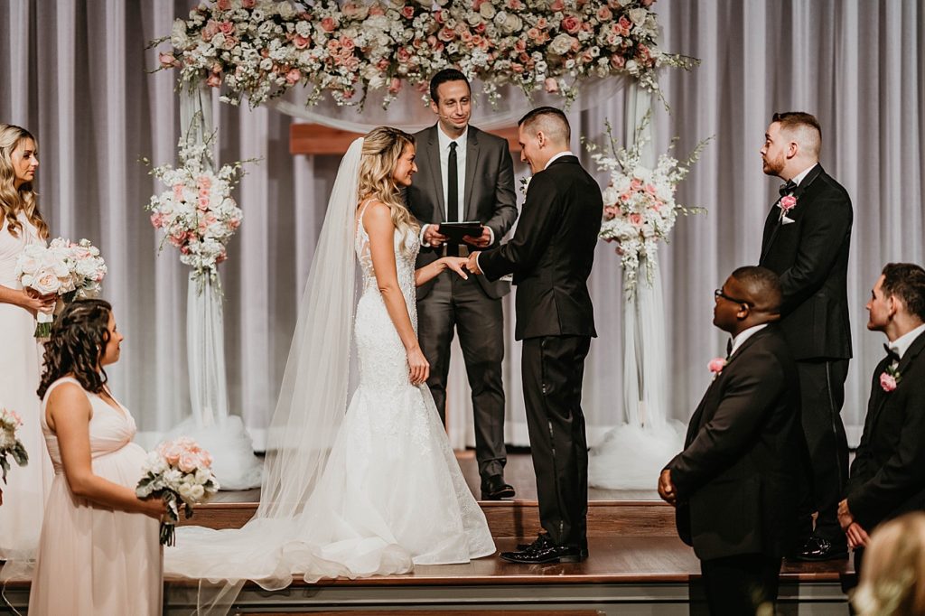Groom putting wedding band on Bride during Ceremony Pelican Club Wedding Photography captured by South Florida Wedding Photographer Krystal Capone Photography
