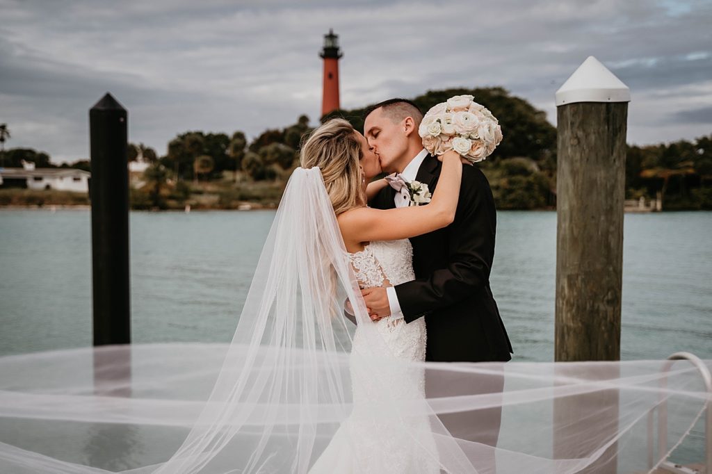 Bride and Groom kissing on ocean dock Pelican Club Wedding Photography captured by South Florida Wedding Photographer Krystal Capone Photography