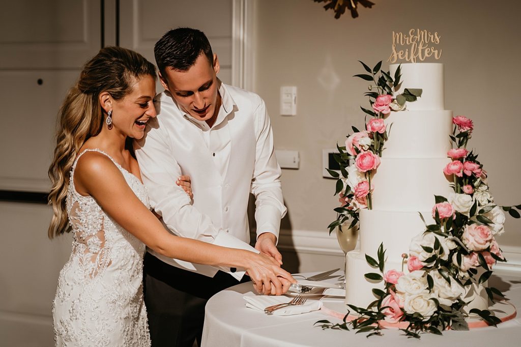 Bride and Groom cutting wedding cake Reception Pelican Club Wedding Photography captured by South Florida Wedding Photographer Krystal Capone Photography
