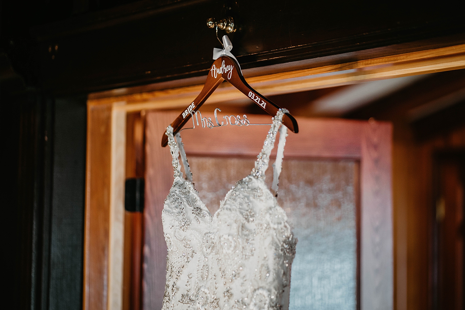 Detail shot of wedding dress hanging on personalized coat hanger