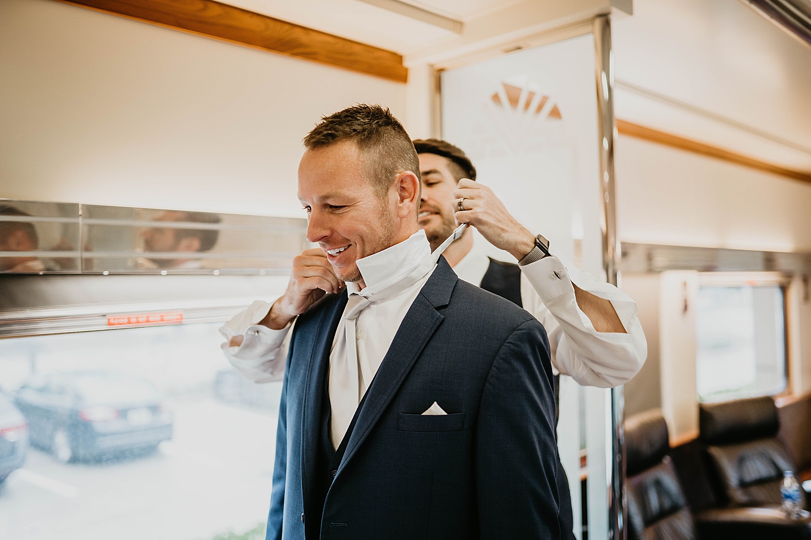 Groom getting ready getting helping putting on tie