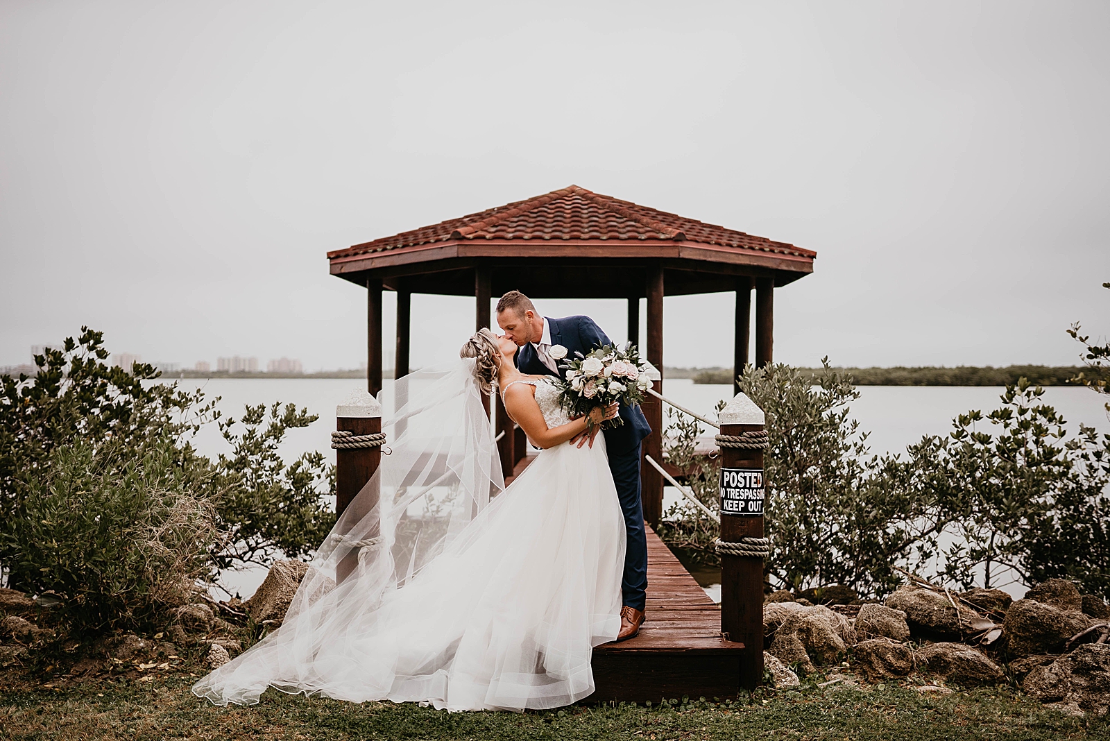 Bride and Groom dipping and kissing by the water