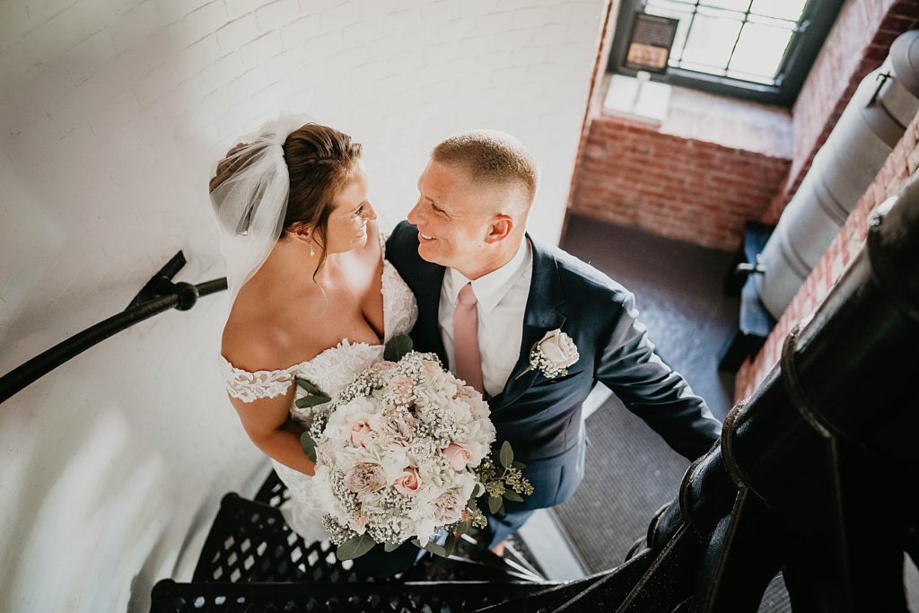 Bride and Groom holding each other on lighthouse staircase