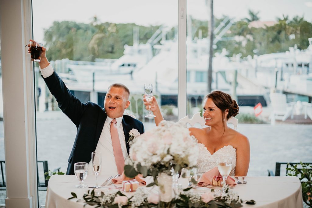 Bride and Groom holding glasses up for cheers