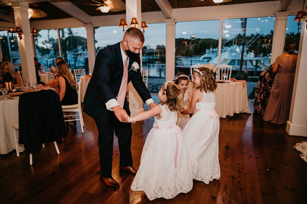 Groom dancing with flower girls